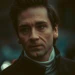 Close-up portrait of a man in Milan, Italy with moody lighting and a contemplative expression.